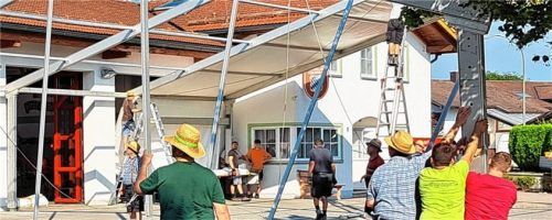 Die Mitglieder der Feuerwehr stellen mit vereinten Kräften und kameradschaftlicher Verbundenheit ein großes Zelt am Feuerwehrhaus auf.Foto Strim
