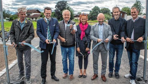 Ein Bandteil als Erinnerung: (von links) Felix Schwaller, Stephan Schlier, Josef Schwaiger (Seniorchef), Steffi Baier (Anliegerin), Denis Weisser (Architekt), Martin Karl (Landschaftsarchitekt) und Franz-Josef Schwaiger (Juniorchef) freuen sich über die Erschließung des Baugebiets, die in den letzten Zügen liegt.Foto Stache
