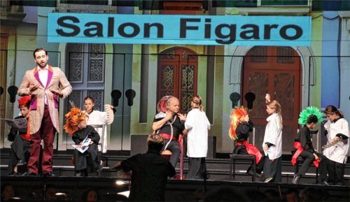 In Figaros Friseursalon flogen Kämme und Haarscheren, von Kinderhand geführt, durch die Luft. Sogar Rossini (Bildmitte Ludwig Baumann) war Kunde. Der Immlinger Kinderchor hatte großen Anteil am generationsübergreifenden Opernspaß.Foto benekam