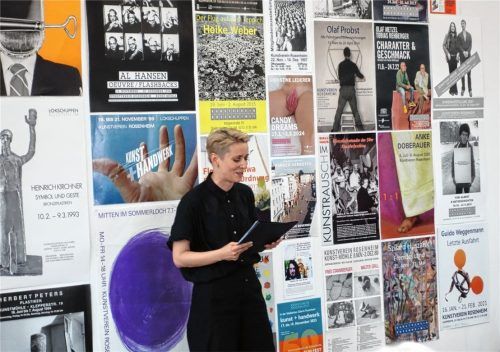 Kunstvereinsvorsitzende Dr. Olena Balun begrüßte die Gäste vor einer Wand mit Plakaten zu Ausstellungen der vergangenen Jahrzehnte. Foto Friedrich