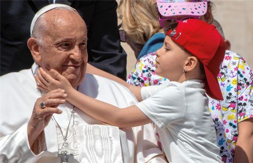 Papst Franziskus bei seiner wöchentlichen Generalaudienz auf dem Petersplatz im Vatikan. Und auch wenn seiner Kirche in Deutschland die Anhänger davonlaufen, gibt es viele neue Christen in aller Welt – dieser Bub scheint den Pontifex zumindest sehr zu schätzen. Foto dpa
