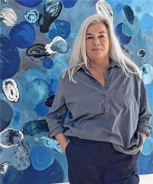 Susanne Meier zu Eissen-Rau ist Künstlerin aus Münster, die in der Galerie „Helligkeit“ ausstellt. Ihr Bild im Hintergrund wurde mit Buchbindeleinen erstellt. Foto Meier zu Eissen-Rau