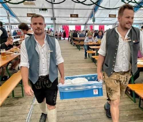 Tobi Rinke und Dominik Hiehler (rechts) bringen benutztes Geschirr und Besteck auf den kürzesten Weg zum Fußballer-Küchenzelt.
