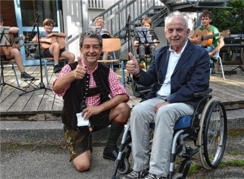 Über das größte „Stück vom Spendenkuchen“ freuen sich gemeinsam Rektor Markus Beham (links) und Inntalhilfe-Vorstand Herbert John, im Hintergrund die Gitarren-Schüler. Foto Ruprecht