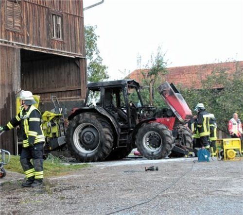 Der fast vollständig ausgebrannte Traktor steht vor der geretteten Scheune. Foto Reisner