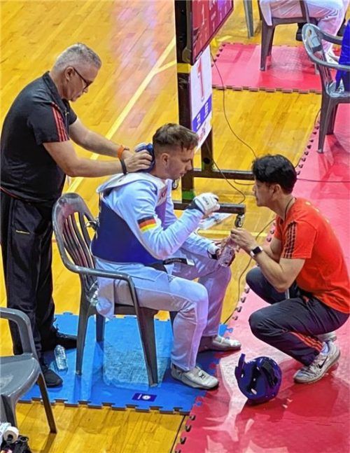 Dr. Frank Düren (stehend) an der Matte bei der Betreuung eines deutschen Sportlers der Taekwondo-Militär-WM-Mannschaft in Mungyeong/Republik Korea.