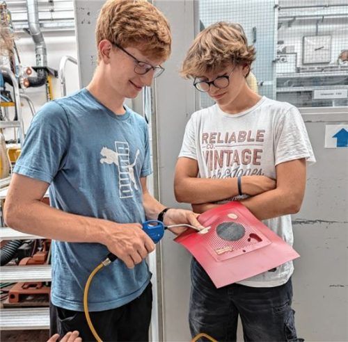 Maximilian (17) und Simon (15) beim Verwenden einer Druckluftpistole für das Herauslösen der Werkstück-Vorlagen nach dem Thermoformen.Foto Grund