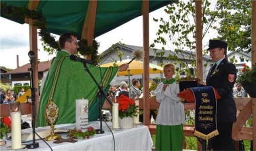 Pfarrer Martin Gehringer segnet das neue Fahnenband, das Julia Eberhard hielt.
