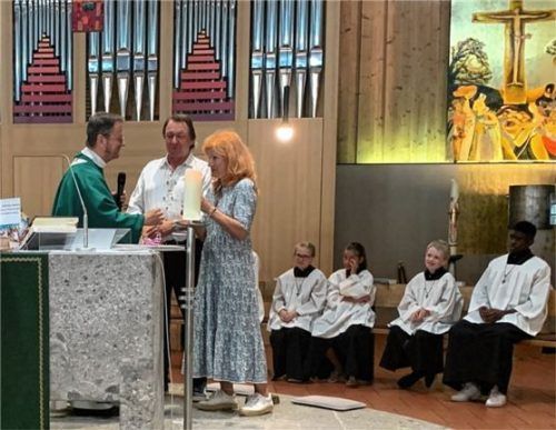 Pfarrer Scheurenbrand (links) verabschiedet den langjährigen Mesner Roland Schwarzmüller (Mitte) und bedankt sich in seiner Ansprache auch bei dessen Frau Hildegard Schwarzmüller. Foto  re