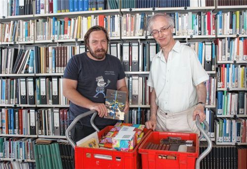 Stadtarchivar Konrad Kern (rechts) übergibt Tomáš Cidlina die allerletzten Restbestände des Haidaer Archivs sowie Geschenke für die Mitarbeiter und ein ganz seltenes Waldkraiburg-Buch. Foto Huckemeyer