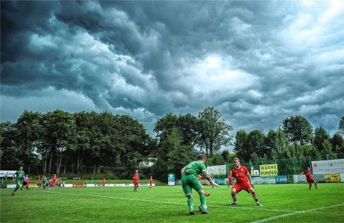 Vor dramatischem Gewitterhimmel versucht Siegsdorfs Josef Wittmann gegen Ende der ersten Halbzeit am Saaldorfer Michael Schreyer (rechts) vorbeizugehen.Foto Hans Weitz