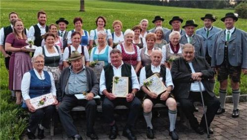 Vorsitzender Alois Hemeter und sein Stellvertreter Hans Mayr (stehend rechts) mit den geehrten Vereinsmitgliedern. Foto Trachtenverein