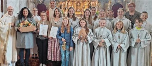 Die Schar der Pittenharter Ministranten, Lektoren und Kommunionhelfer mit Pfarrer David Mehlich, Diakon Wolfgang Mösmang und Gemeindereferentin Conny Doppelberger am Schluss des Festgottesdienstes in der Pittenharter Pfarrkirche. Foto  Künzner-Hingerl