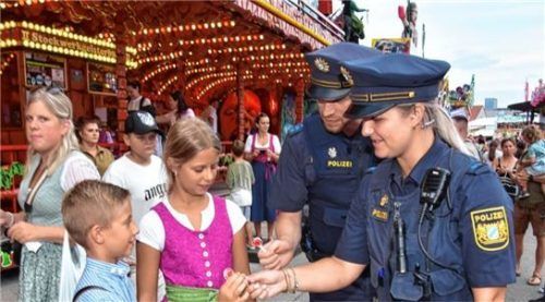 Polizeihauptmeister Michaela Meyer und Christoph Dienhart verteilen kleine Geschenke an die Kinder auf dem Herbstfest.