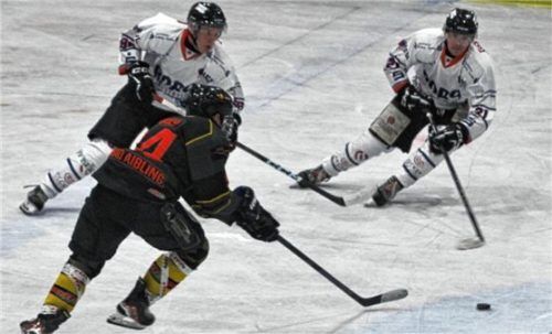 Thomas Neumaier (in Schwarz, links) im Kampf um den Puck gegen die Dorfener Florian Hartl (links) und Michael Franz. Foto Hadersbeck