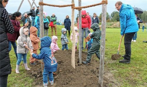 Bürgermeister Stefan Adam (rechts) pflanzt mit den Mühlstätter Kindern symbolisch einen Baum zur Spielplatz-Eröffnung.Foto Heinz