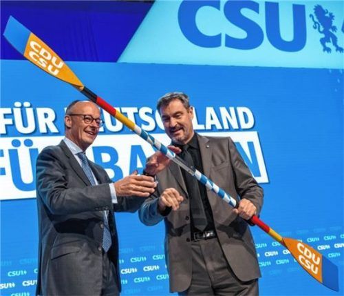 CDU-Chef Friedrich Merz (links), Kanzlerkandidat der Union, bekommt auf dem CSU-Parteitag von Markus Söder, Vorsitzender der CSU, ein Paddel mit dem Logo der beiden Parteien überreicht. Foto dpa