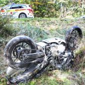Biker kommt in Wald von Straße ab
