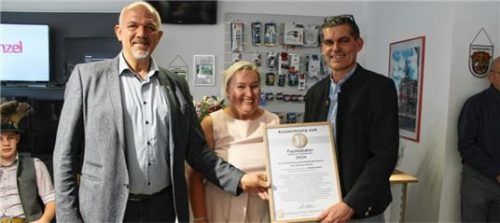 Feierlich übergab Bürgermeister Josef Eisner (von links) den 1a-Fachhändlerpreis an Martina und Michael Heinzel. Foto RE