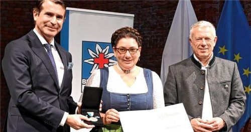 Für besondere Verdienste in der Bergrettung wurde Martina Bauer (Mitte) mit dem Leistungsabzeichen in „Silber“ der Bergwacht Bayern und damit als eine „Heldin der Berge“ von Bayerns Europaminister Eric Beißwenger (links) und Thomas Lobensteiner, Vorsitzender der Bayerischen Bergwacht (rechts), ausgezeichnet.Foto Bayerische Staatskanzlei