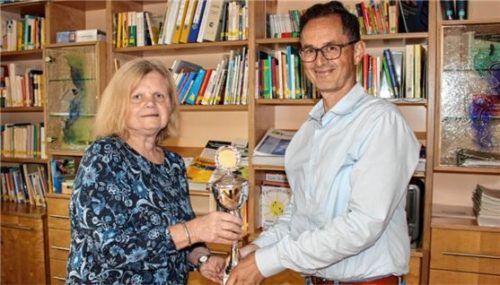 Kinderdorf-Verwaltungsleiter Hannes Klapos überreichte Lissi Hochreiter zu ihrem 50-jährigen Dienstjubiläum einen Pokal.Foto lintz