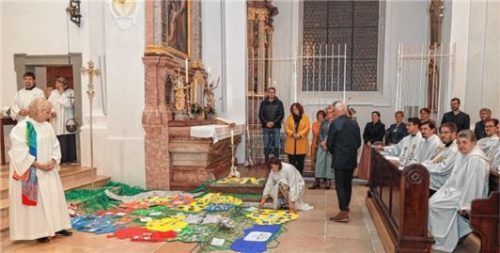 Wie bei einem Riesenpuzzle legten Angehörige aus den unterschiedlichen Pfarreien auf dem Boden der Stadtpfarrkirche ihre Bereiche wie bei einem Puzzle zu einem „großen Ganzen“, dem neuen Dekanat Traunstein, zusammen.