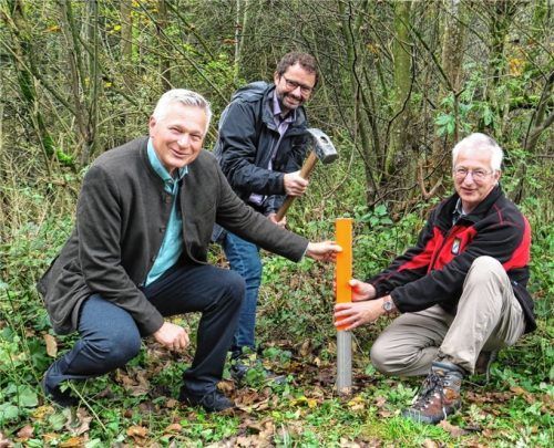 Bürgermeister Johannes Zistl (Feldkirchen-Westerham) schlug symbolisch den neuen Grenzpfahl ein, flankiert von seinem Bruckmühler Amtskollegen Richard Richter (links) und Vermessungsamts-Leiter Falk Brem.Foto baumann