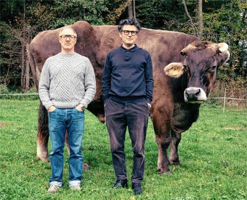 Die Schauspieler Simon Schwarz und Manuel Rubey (rechts) vor dem Ochsen Asterix auf einer Weide in Österreich. Die beiden Künstler kommen am 4. November mit ihrem Kabarettprogramm in das Rosenheimer Ballhaus. Foto Stefan Robitsch
