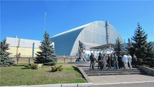 Eine Touristengruppe am Mahnmal vor dem 1986 explodierten Block IV des Atomkraftwerks Tschernobyl. Foto dpa (ARCHIV)