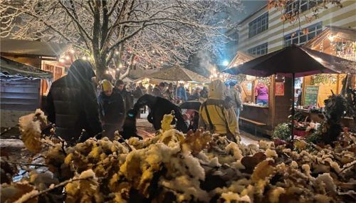 Idyllisch unter Bäumen mit roten Weihnachtskugeln und beleuchteten Hecken sind die 24 Hütten aufgebaut. Sie bieten Handwerk und Kulinarik auf vielfältige Weise.