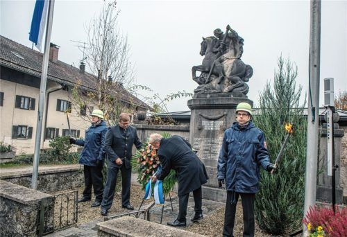 Im Gedenken an die Verstorbenen legen Peter Niedermeier (rechts) und Christian Mayer (links), umrahmt von der Ehrenwache der Feuerwehr, einen Kranz am Kriegerdenkmal ab. Foto stache