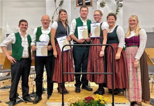 Kathrin Flory (rechts), Thomas Krapichler (links) und Dirigentin Martina Riedl (Zweite von rechts ) zeichneten Harald Höschler (Zweiter von links), Marlene Binder (Dritte von links), Stephan Wörndl (Mitte) und Anna Hafner (Dritte von rechts) der Blaskapelle Bruckmühl aus. Foto neuwirth