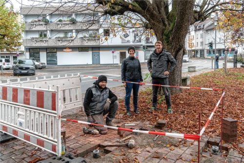Mobilitätsmanagerin Veronika Winkler (Mitte) und Benjamin Nabel vom Bauamt (rechts) bei der „Fahrradständerbaustelle“ vor dem Stadtcafé: Die Abstellbügel bekommen ein solides Fundament, damit sie auch felsenfest stehen.