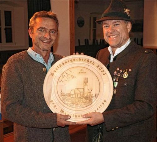 Schützenmeister Andreas Freund junior (rechts) übergibt dem Dorfschützenkönig von Wildenwart Florian Fuihl die Siegerscheibe.Foto Rehberg