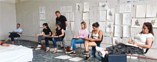 Unterrichtssituation des Studiengangs. Angeschnitten ist das Podest mit Aktmodell in der Mitte, welches gezeichnet wird. Ebenfalls im Bild ist Heribert Heindl, der Studiengangsleiter. Fotos re