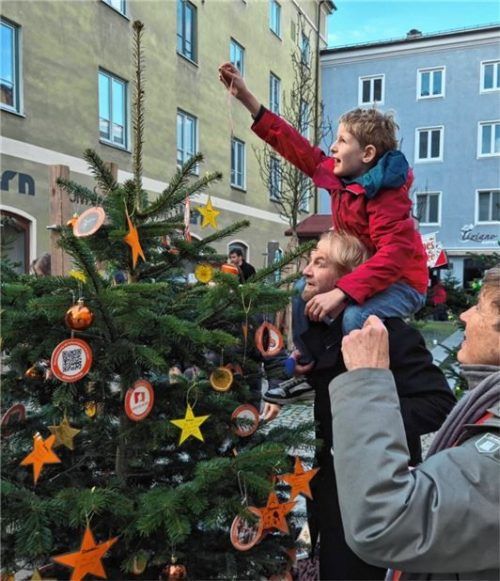 Ganz schön hoch: Damit der Christbaum von Donum Vitae eine schöne Spitze bekommt, halfen Stadtmanager Simon Arnold und sein Sohn beim Schmücken aus. Fotos Rieger