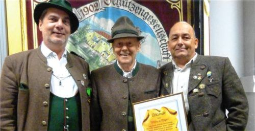 Gauschützenmeister Bernhard Brehmer (links) und Schützenmeister Jürgen Dettelbacher (rechts) überreichen die Urkunde zur Ehrenmitgliedschaft an Wilfried Rüger.Foto Wastl