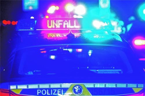Während einer Unfallaufnahme spiegeln sich Blaulicht und der LED-Schriftzug „Unfall“ auf dem nassen Dach eines Polizeistreifenwagens. Foto dpa