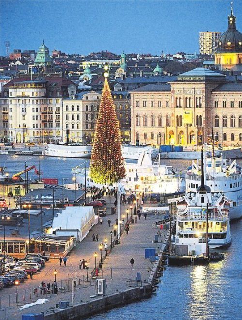 Wichtel und Tannen: Hofgeist Tomte (l.) sitzt im Fenster. Am Kai von Skeppsbron (gr. F.) funkelt ein riesiger Christbaum.