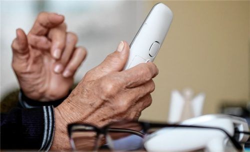 Eine ältere Dame nimmt in ihrer Wohnung ein Telefongespräch an. Immer wieder gelingt es falschen Polizeibeamten, Menschen dazu zu bringen, ihnen Geld oder Wertgegenstände auszuhändigen. Foto dpa