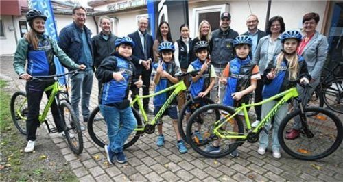 Lehrerin Larissa Falk, Konrektor Stefan Mayr und Schulleiter Markus Beham (von links) mit den Vertretern der unterstützenden Firmen und einigen Schülern mit ihrer neuen Ausrüstung samt Mountainbikes.Foto Ruprecht