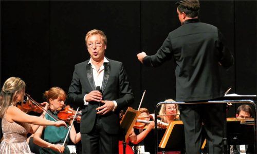 Max Müller, der singende Conférencier (vorne, links), der Dirigent Daniel Spaw und die Münchner Symphoniker gestalteten gemeinsam das Neujahrskonzert.Foto janka
