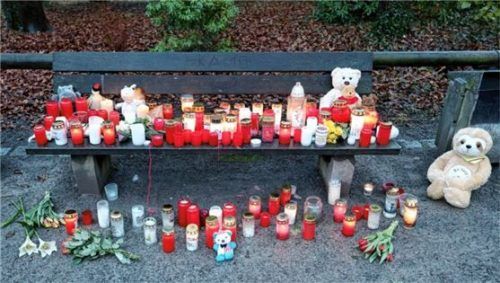 Trauerkerzen, Blumen und Kuscheltiere liegen nach dem tödlichen Angriff in einem Park am Tatort in Aschaffenburg auf einer Bank.Foto DPA