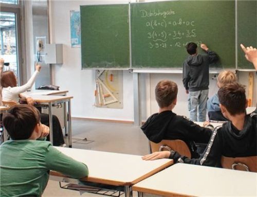Unterricht, wie wir ihn alle kennen: Adrian aus der 7. Klasse erklärt das Distributivgesetz mit weißer Kreide auf der grünen Tafel.