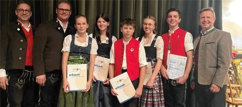 Zahlreiche Urkunden und Abzeichen verliehen Simon Pertl, Vorsitzender der Musikkapelle Aschau (Zweiter von links), und Benedikt Paul, Verbandsjugendleiter des Musikbundes Ober- und Niederbayern (ganz rechts), an Josefine Hobelsberger, Ziva Glöckner, Franz Maurer, Helena Rottmüller und Korbinian Anner. Für erstklassige Ausbildung beim Nachwuchs ist also gesorgt, was Dirigent Michael Morgott (ganz links) sichtlich freut.Foto Kirchner