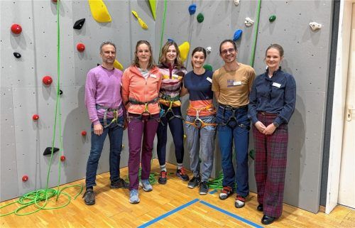 Klinikgeschäftsführerin Julia Tamborini (rechts) und der Leiter der Sport- und Bewegungstherapie, Dr. Alexander Heimbeck (links), mit seinem Team freuen sich über die Erweiterung der therapeutischen Kletterwand.Foto re