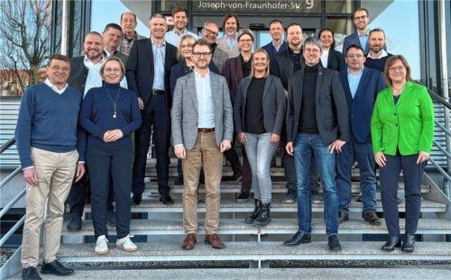 Lächeln für das Gruppenfoto des IHK-Regionalausschusses Rosenheim vor dem Logistik-Kompetenz-Zentrum in Prien. Die Stimmung war jedoch getrübt.Foto IHK München