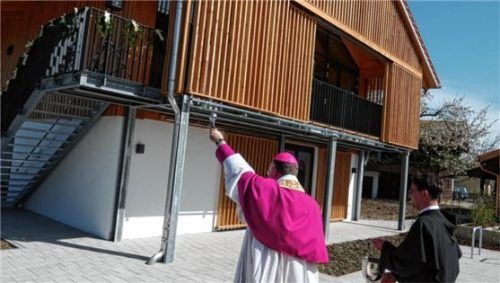 Weihbischof Rupert Graf zu Stolberg bei der Segnung des Pfarrsaals im neuen Pfarrheim der Grabenstätter Pfarrgemeinde mit Pfarrverbandsleiter Pater Vasile Dior.