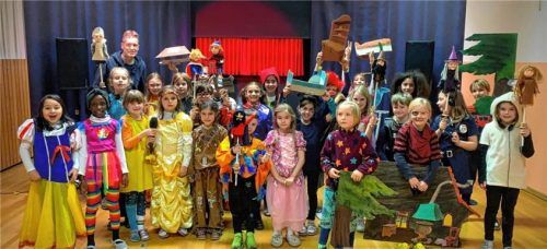 Die Kinder der Grundschule Westerndorf halten mit Theater-Künstler Joachim Gößler (hinten links) Pupppenfiguren hoch. Foto re