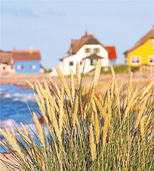 Ein eigenes Häuschen im Urlaub kann so schön sein: Hier schmiegen sich bunte Ferienvillen in Heiligenhafen an die Küste.
